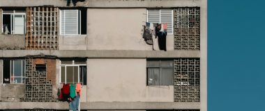 Fachada de prédio residencial popular, com roupas no varal e cobogó, em São Paulo